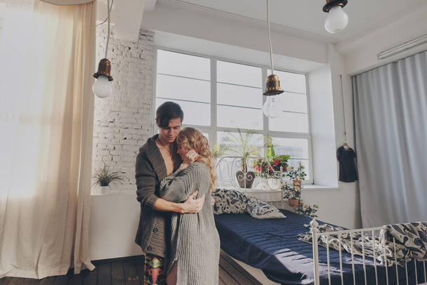 attractive man and woman in the bedroom together cuddling cute - Photo, Image