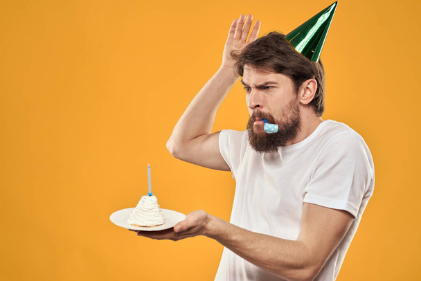 compleanno ragazzo in un cappello con torta divertimento giallo sfondo partito - Foto, immagini