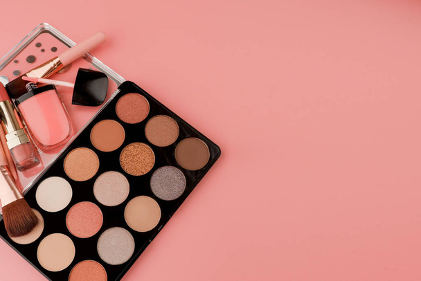 Various makeup productson pink background with copyspace. - Fotografie, Obrázek