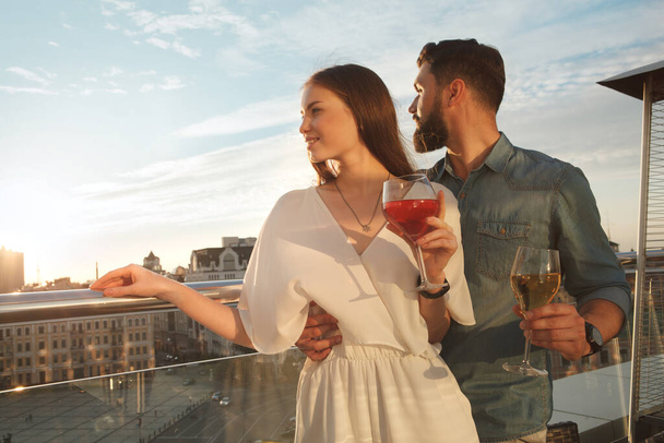 Beautidul elegante pareja mirando a las vistas de la ciudad desde la terraza del restaurante, espacio para copiar - Foto, imagen