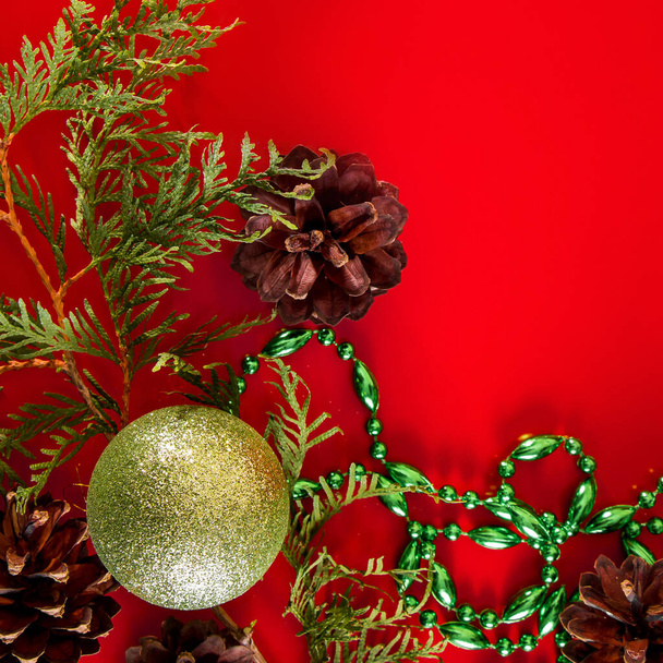 Composizione festiva di coni e palline di Natale su sfondo rosso per cartoline di design e auguri. - Foto, immagini
