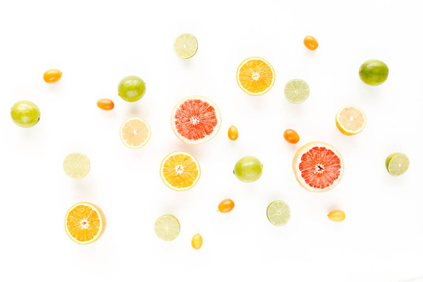 Creative pattern made of summer tropical fruits: grapefruit, orange, lemon, lime and leaves ficus. Food concept. flat lay, top view - Foto, Imagem