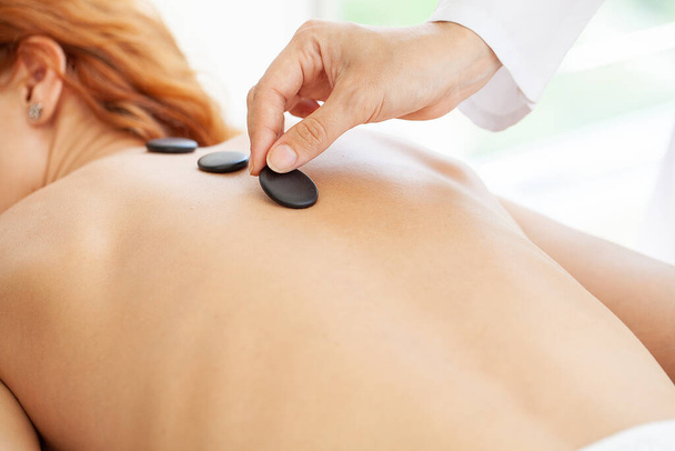Femme obtenir un massage avec des pierres chaudes - Photo, image