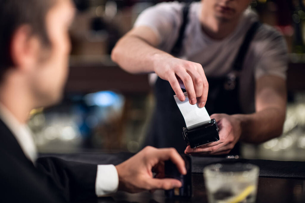 o bartender aceita pagamento com cartão de crédito no bar - Foto, Imagem