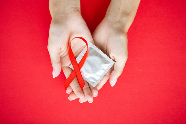 Close Up Frau Hand hält rote Schleife HIV, Welt-AIDS-Tag Bewusstseinsband. - Foto, Bild