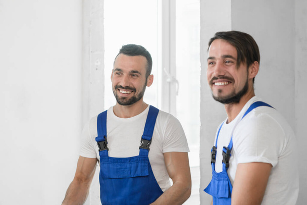 Two men in blue overalls. They are smiling - Fotoğraf, Görsel