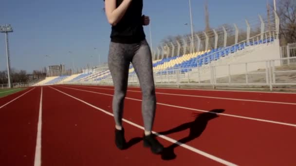 Atlétikai vonzó fit fiatal nő fut kocogás lassított felvételű, szabadtéri nagy stadion edzés napsütéses tavaszi napon - Felvétel, videó