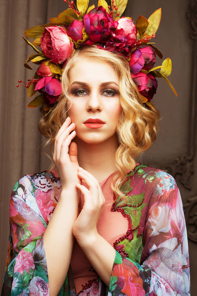 Beautiful blond woman in a dress of floral colors with wreath of flowes - Foto, afbeelding