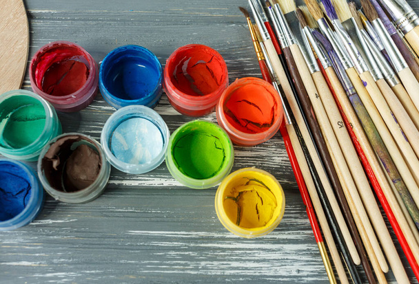 Close-up de pincéis de pintura artista, paleta e aquarelas no fundo de madeira cinza grunge. Conjunto de tintas multicoloridas.  - Foto, Imagem