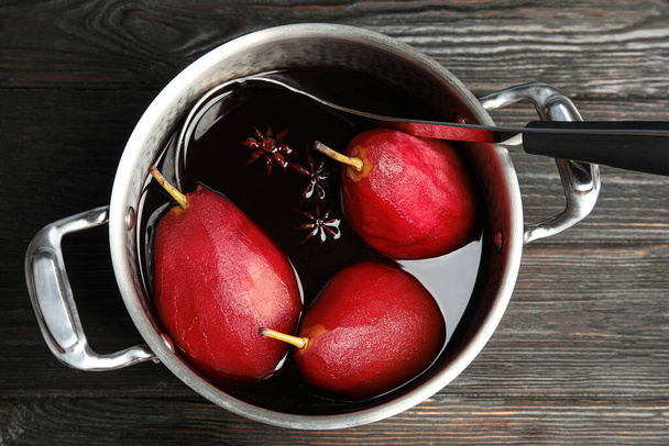 Poaching pears in mulled wine on wooden table, top view - Foto, imagen