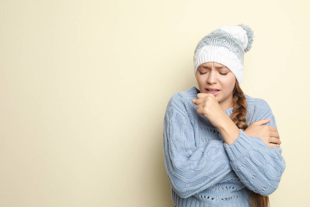 Young woman wearing hat coughing on light background, space for text. Cold symptoms - Foto, immagini