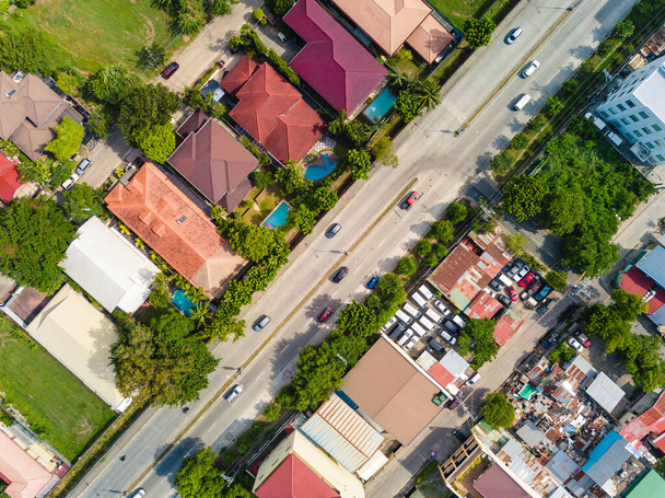 Сравнение богатого подразделения и бедной области, изобилующей трущобами, разделенными широким проспектом. Съёмки в Мунтинлупе, Филиппины. - Фото, изображение