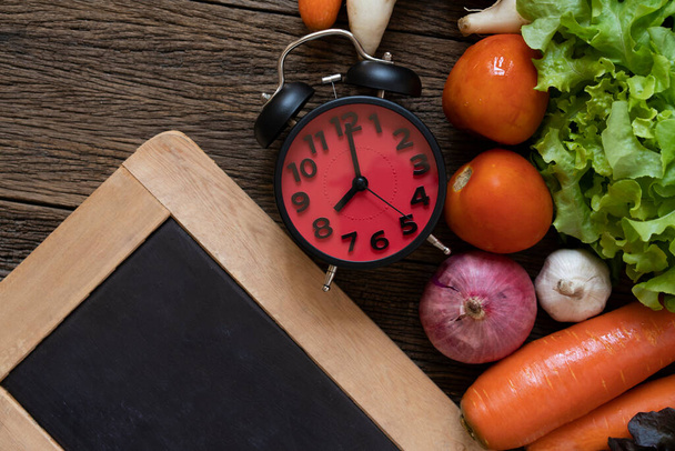 Food clock with blackboard. Healthy food concept on wooden background - Fotografie, Obrázek