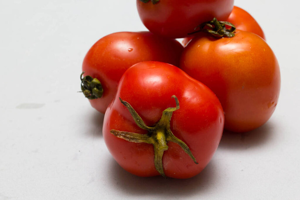 sappige rode tomaten in tafelkleed. caro-achtergrond - Foto, afbeelding