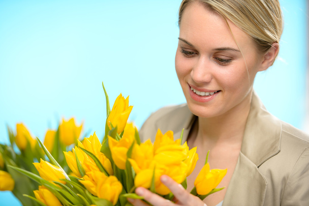 Woman looking down at spring yellow tulips - Фото, изображение