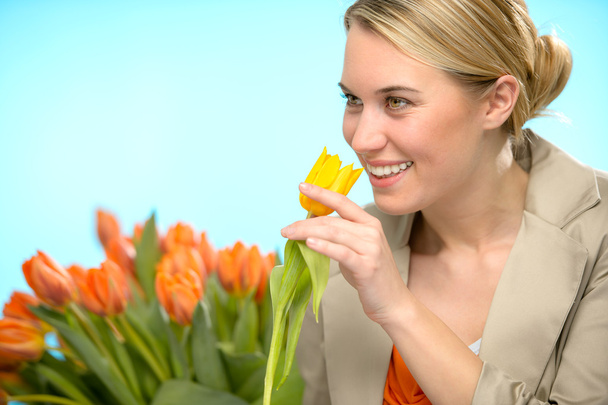 Woman smelling one yellow tulip spring flowers - Fotoğraf, Görsel
