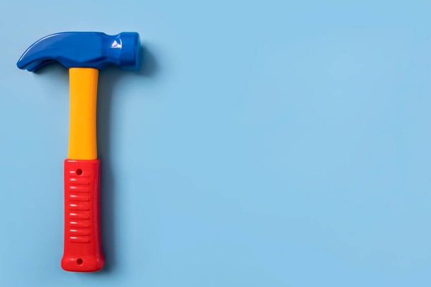 Children's training toy plastic hammer on a uniform blue background. copyspace, a place for your text. - Foto, imagen