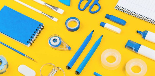 Assorted office and school white and blue stationery on bright yellow background. Organized knolling for back to school or education and craft concept. Selective focus. Banner - Photo, image