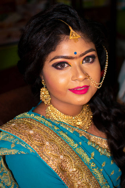 una ragazza adolescente indiana felice con abbigliamento etnico indiano e ornamenti in una festa di ricevimento di matrimonio - Foto, immagini