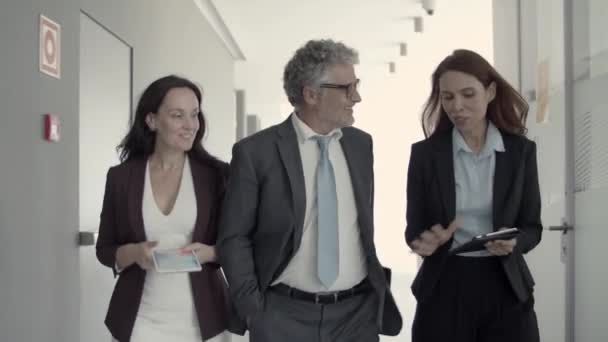 Alegre gente de negocios exitosa hablando mientras camina - Metraje, vídeo