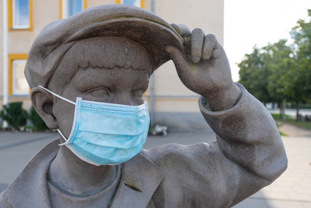Retour à l'école pour les enfants et les élèves pendant l'épidémie de COVID-19 ou de Coronavirus, retour à l'école avec de nouvelles règles, statue d'enfant portant un masque - Photo, image