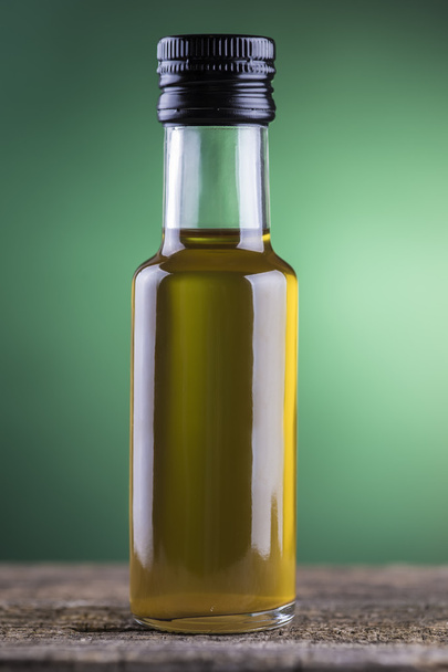 Olive oil bottle with green spotlight background - Φωτογραφία, εικόνα