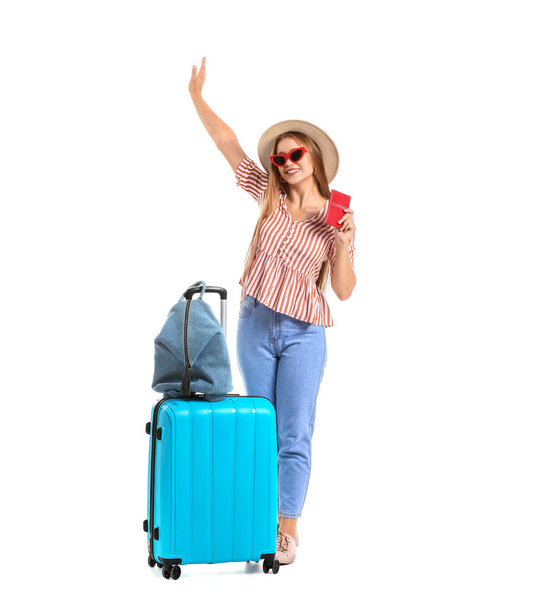 Νεαρή γυναίκα με αποσκευές σε λευκό φόντο. Ταξιδιωτική έννοια - Φωτογραφία, εικόνα