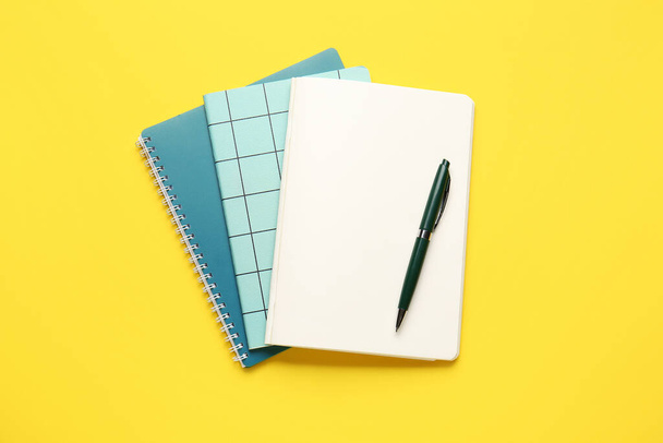 Notebooks and pen on color background - Foto, Bild