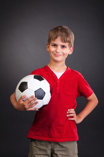 Boy is holding a football ball - Фото, изображение