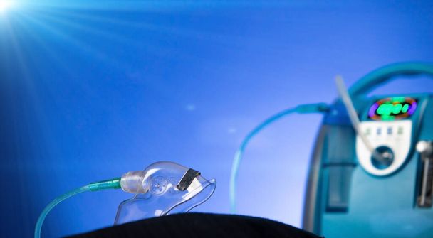 Lääketieteellinen laite Yksilöllinen sininen valkoinen kannettava happisylinteri kaasun asettamiseksi potilaille, joilla on hengityselinten sairauksia, laita happinaamari kopiotilaa, studio valaistus sininen tausta - Valokuva, kuva