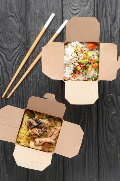 Κουτιά με νόστιμο τηγανητό ρύζι στο τραπέζι - Φωτογραφία, εικόνα