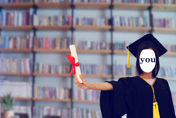 неизвестная женщина в выпускном платье показывает диплом в руке с пятно книжной полки с фоном, концепция образования - Фото, изображение