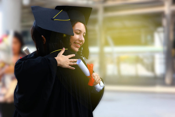 Teenie-Mädchen-Paar im Abschlusskleid umarmt sich am Abschlusstag stolz - Foto, Bild