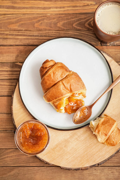 Jar of tasty apricot jam and croissant on table - Foto, Imagen