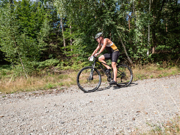 Radvanec, Tsjechië - 23 augustus 2020. Het Samuel XC triatlon evenement. Race veteraan deelnemen mtb hobby race en rit bergafwaarts uit het bos. - Foto, afbeelding