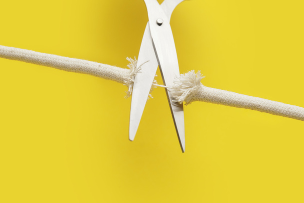 Scissors with frayed rope on color background - Photo, Image