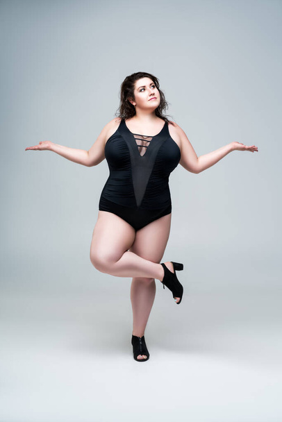 Sexy plus size fashion model in black one-piece swimsuit, fat woman in lingerie on gray background, body positive concept - Φωτογραφία, εικόνα