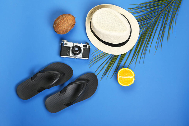 Male flip-flops with hat and photo camera on color background - Photo, Image
