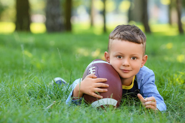 Kisfiú rögbi labdával a szabadban - Fotó, kép