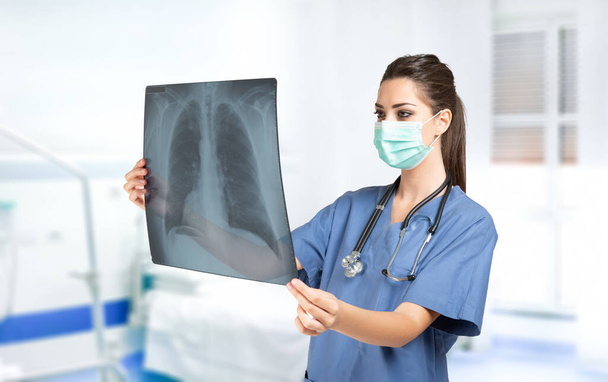 Young woman doctor holding a lung radiography, coronavirus and lung illness concept - Φωτογραφία, εικόνα