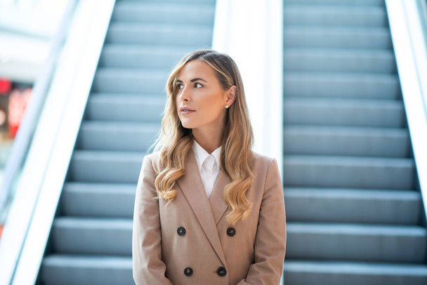 Businesswoman waiting and thinking near an escalator - Foto, immagini