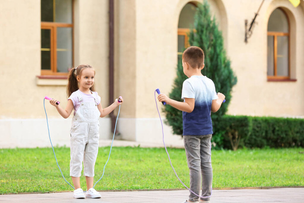 Cute little children jumping rope outdoors - Photo, Image