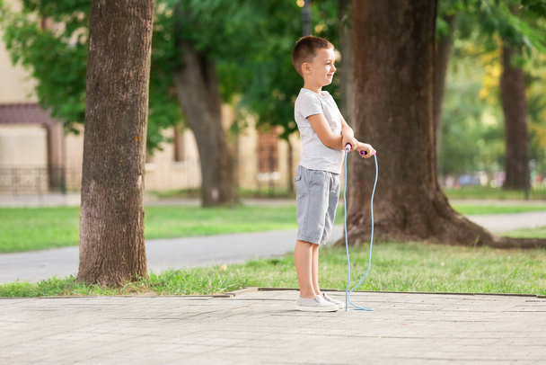 Милий маленький хлопчик стрибає мотузкою на відкритому повітрі
 - Фото, зображення