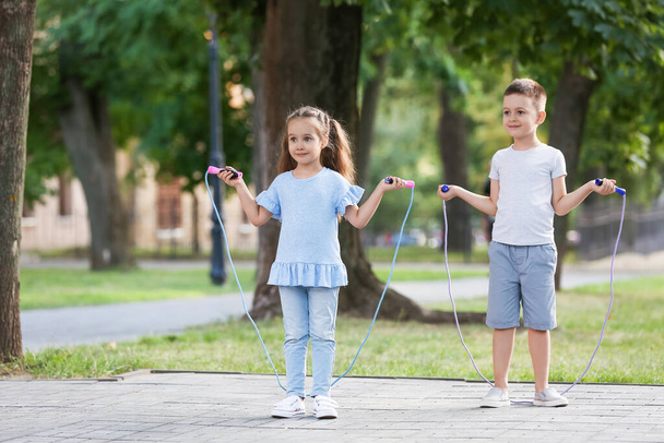 Roztomilé malé děti skákání lano venku - Fotografie, Obrázek