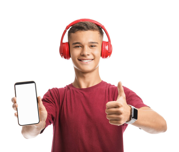 Adolescente con auriculares y teléfono móvil sobre fondo blanco - Foto, imagen