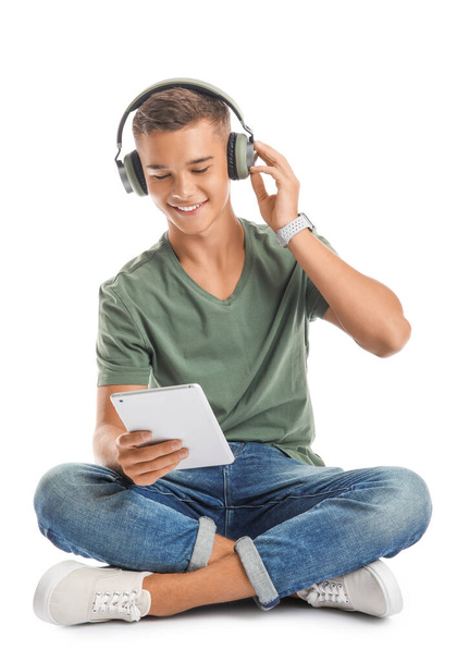 Teenage boy listening to music on white background - Zdjęcie, obraz