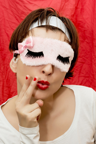 ελκυστική γυναίκα με μάσκα ύπνου μιμείται το κάπνισμα - Φωτογραφία, εικόνα