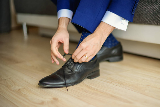 Groom is wearing shoes in blue wedding clothes indoors. The businessman wears shoes - Photo, Image