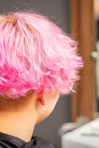 Πίσω όψη του ροζ hairstyle της νεαρής γυναίκας μετά τη βαφή των μαλλιών και κάνοντας ανταύγειες στο σαλόνι ομορφιάς - Φωτογραφία, εικόνα