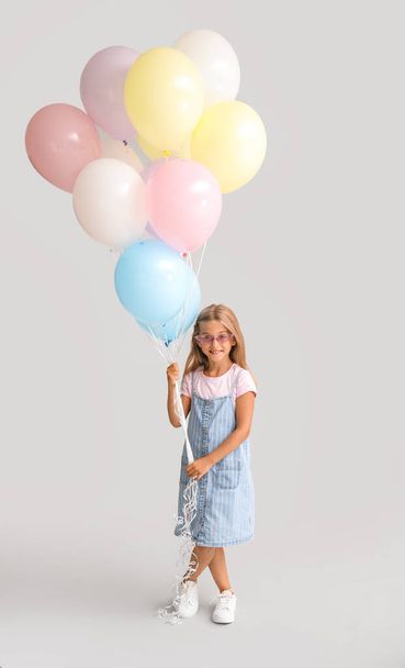Niña con globos sobre fondo gris - Foto, imagen